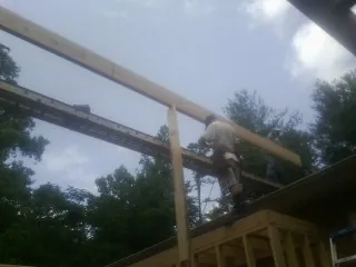 Carpenter setting a ridge beam over a new addition frame — Ice Dam Removal by Roofing Brothers in Sherborn