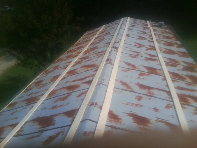 Rusted metal roof panels with new wood purlins before replacement — Storm Damage Roof Repair in Sherborn by Roofing Brothers