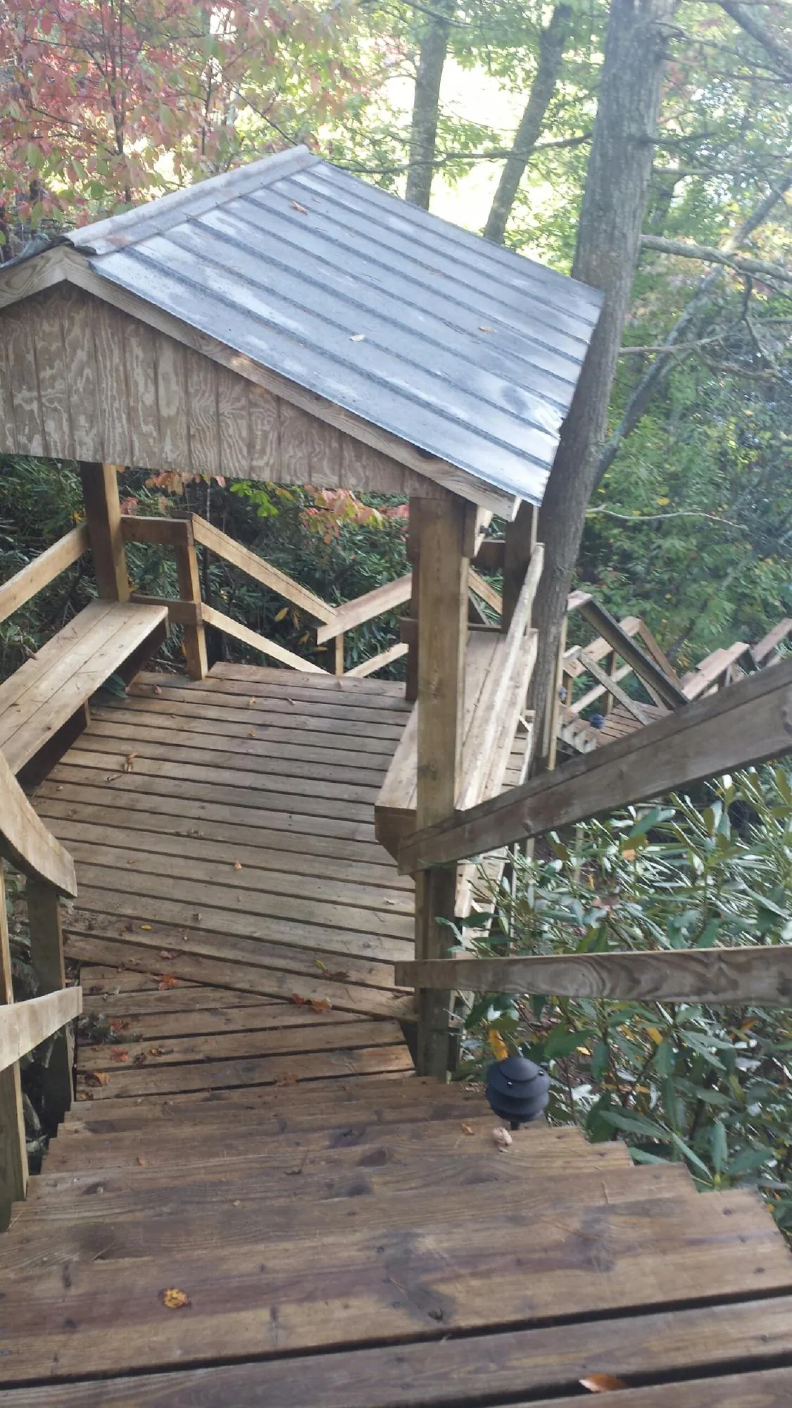 Metal roofed shelter over wooden steps on a wooded walkway — Skylight Repair & Installation work by our crew in Sherborn