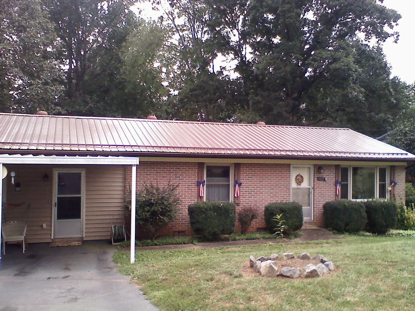 Bronze metal roof and carport on a brick ranch home — Roof Repair work by our crew in Sherborn